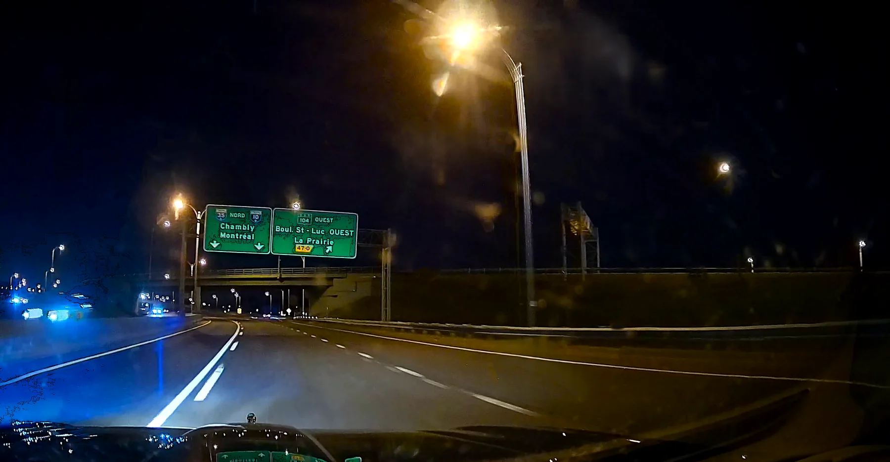 Night road signs directing traffic toward Montreal