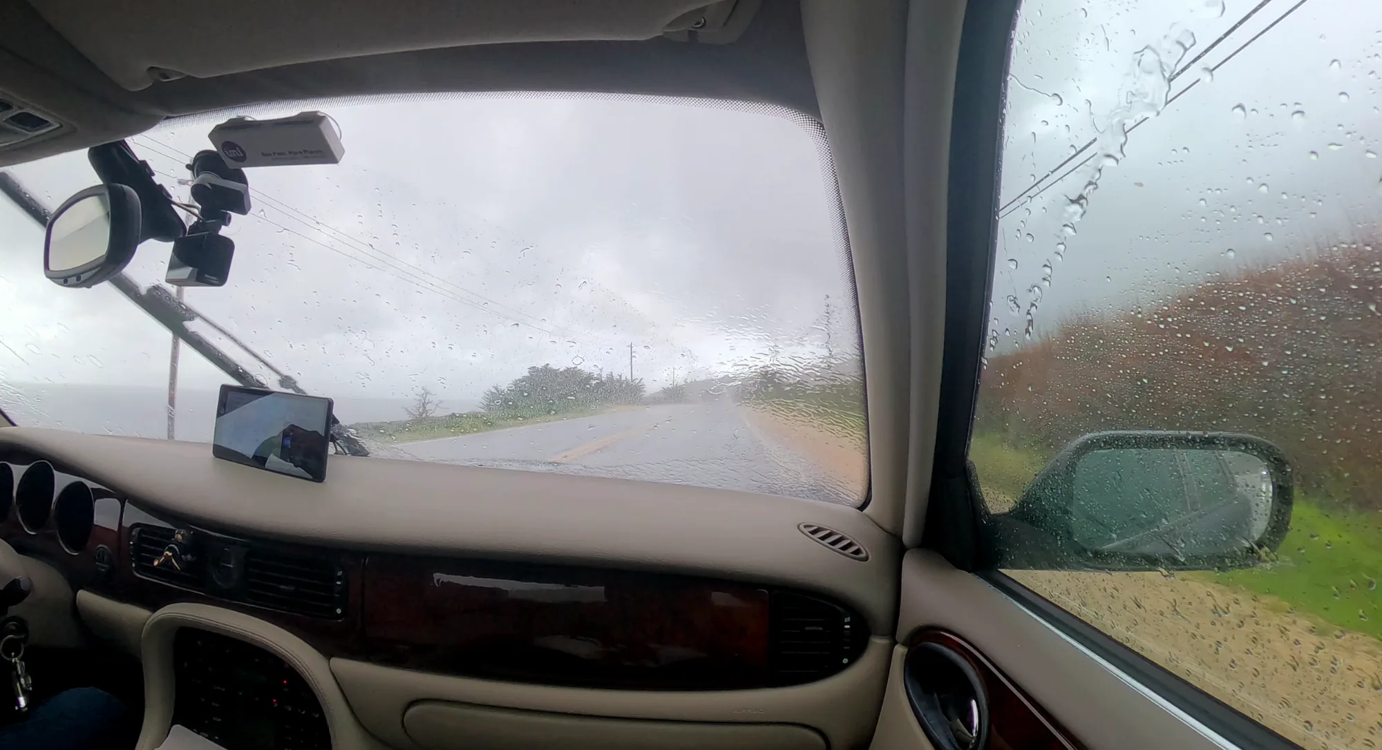 Rainy coastal road seen from inside the Jaguar X308